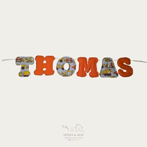 Personalised memory bunting by Needle and Nest spelling THOMAS in orange felt and construction vehicle print fabric - handmade nursery decor
